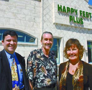 Photo of Happy Feet Plus three owners standing outside of retail building.